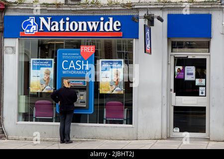 Warminster, Wiltshire, Royaume-Uni - 12 octobre 2014 : Une femme retire de l'argent d'un guichet automatique de la Nationwide Building Society à Warminster, Wiltshire, Angleterre, Royaume-Uni Banque D'Images
