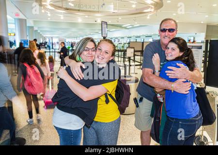 Aéroport international de Miami Florida MIA, terminal intérieur, père mère parents fille s'embrassant disant Au revoir voyage au départ Banque D'Images