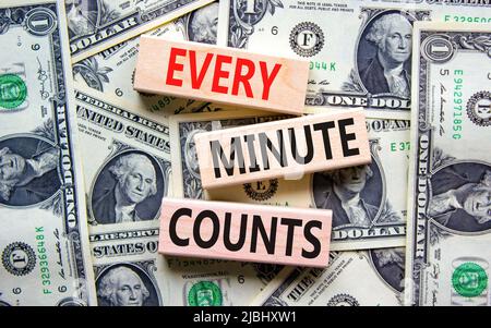 Chaque minute compte le symbole. Concept mots chaque minute compte sur des blocs de bois sur un beau fond de billets de dollar. Entreprise, motivation et Banque D'Images
