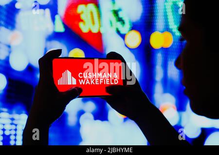 Brésil. 6th juin 2022. Dans cette illustration, une femme silhouetée tient un smartphone avec le logo Cushman et Wakefield affiché à l'écran. (Credit image: © Rafael Henrique/SOPA Images via ZUMA Press Wire) Banque D'Images