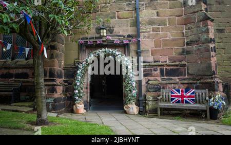 Mariage décoration florale autour de la porte de l'église Sainte-Marie et de la Toussaint, Grand Budworth, Cheshire pendant le jubilé de platine. Banque D'Images