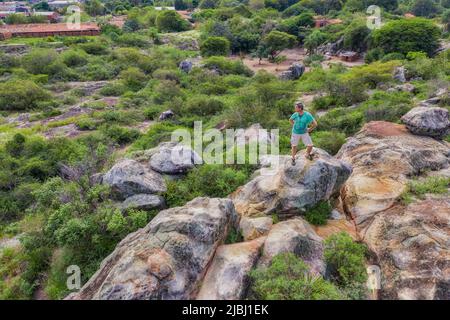 Vue aérienne d'un homme se tenant au sommet d'un plateau rocheux à Tobati, Paraguay. Banque D'Images