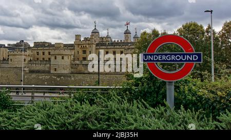 Londres, Angleterre - 17 octobre 2019: Le Palais médiéval la Tour de Londres juxtaposé avec un panneau de métro moderne de Londres. Banque D'Images