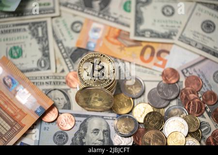Les bitcoins sont empilés sur les billets en dollars et en euros. Pièces de BTC d'or avec pièces de monnaie en dollar, concept de crypto de négociation Banque D'Images