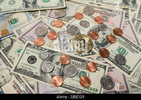Bitcoin sur les billets en dollars. Une facture de cent dollars à côté de pièces en bitcoin d'or et de pièces en dollars. Des centimes aux quartiers des États-Unis. Concept d'échange de crypto Banque D'Images