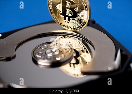 Bitcoin réfléchissant sur le plateau du disque dur. Technologie numérique et concept blockchain. Bitcoin doré sur le disque dur. Banque D'Images