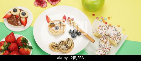 Des toasts sains pour les enfants sur fond coloré. Idée de petit déjeuner sain. Déjeuner ludique. Vue de dessus, plan d'affichage, espace de copie, panorama Banque D'Images