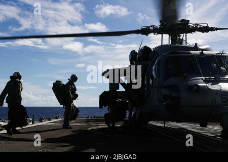 Les marins DE LA MER DES PHILIPPINES (3 juin 2022) embarquent sur un hélicoptère MH-60s Sea Hawk, affecté aux “Chargers” de l’Escadron de combat de la mer (HSC) 14, avant son décollage du croiseur à missiles guidés de classe Ticonderoga USS Mobile Bay (CG 53). Abraham Lincoln Strike Group est en cours de déploiement prévu dans la zone d'exploitation de la flotte américaine 7th afin d'améliorer l'interopérabilité par le biais d'alliances et de partenariats tout en servant de force d'intervention prête à l'emploi pour soutenir une région Indo-Pacifique libre et ouverte. (É.-U. Photo marine par Spécialiste communication de masse 3rd classe Alonzo Martin-Frazier) Banque D'Images