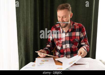 L'investisseur analyse les rapports financiers et les indicateurs de performance clés du marché boursier à l'aide d'analyses et de graphiques de veille stratégique dans le bureau à domicile. Banque D'Images