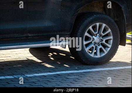 Le vus se fragmente avec la roue arrière, l'ombre de la voiture sur la chaussée par une journée ensoleillée, gros plan Banque D'Images