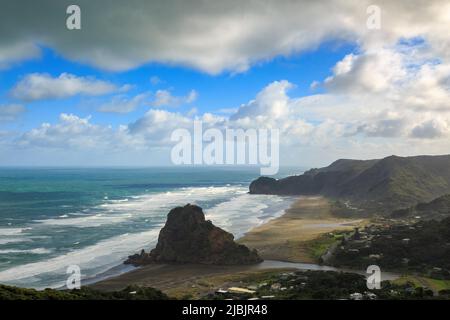 Piha, ville et plage de sable noir de la région d'Auckland, Nouvelle-Zélande. Lion Rock est debout sur le sable Banque D'Images