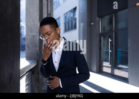 Femme d'affaires afro-américaine près du bureau, se sentant déprimée et toussant mal Banque D'Images