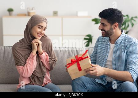 Un mari musulman donne un cadeau à sa femme pour fêter son anniversaire à la maison Banque D'Images