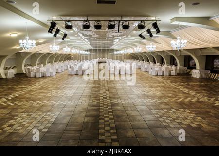 Salle de réception pour réception de mariage avec tables servies et grande piste de danse Banque D'Images