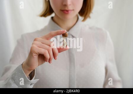 Champignons de psilocybine dans la main de la femme sur fond gris. Voyage aux champignons magiques psychédéliques. Usage médical. Concept de microdosage. Psilocybe cubensis Banque D'Images