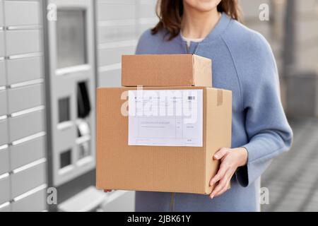 femme avec des boîtes à la machine à colis automatisée Banque D'Images