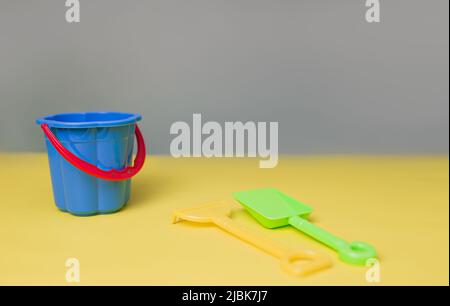 Accessoires de plage sur le bleu et le jaune - bannière des fêtes d'été. Banque D'Images