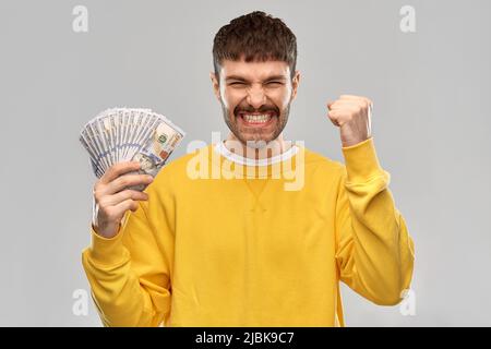 joyeux jeune homme avec de l'argent célébrant le succès Banque D'Images