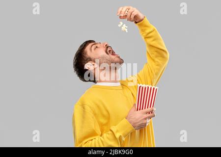 homme dans un chandail jaune en train de sueur du pop-corn Banque D'Images