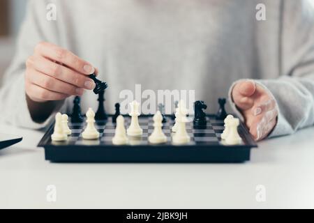 Gros plan des mains de la jeune belle femme jouant aux échecs, étudiant, compétition Banque D'Images