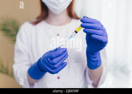 les mains de la femme composent le vaccin dans une seringue, photo de gros plan Banque D'Images