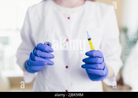 les mains de la femme composent le vaccin dans une seringue, photo de gros plan Banque D'Images