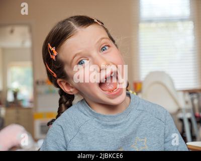 Portrait d'une jeune fille de sept ans souriante qui a perdu ses dents de bébé avant qui sont tombées Banque D'Images