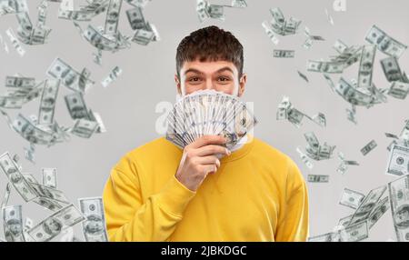 joyeux jeune homme dans un sweat-shirt jaune avec de l'argent Banque D'Images joyeux jeune homme dans un sweat-shirt jaune avec de l'argent Banque D'Images