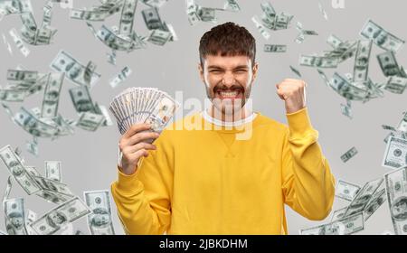 joyeux jeune homme avec de l'argent célébrant le succès Banque D'Images