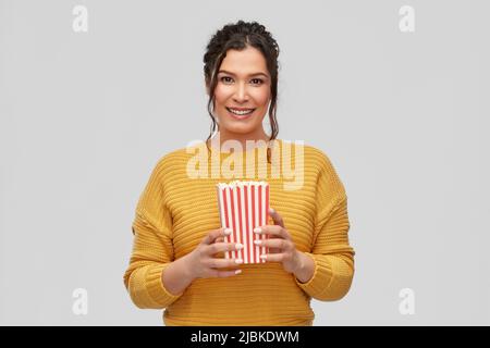 bonne jeune femme souriante avec un seau de pop-corn Banque D'Images