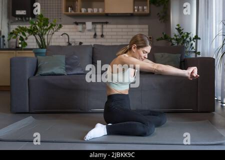 Une femme d'âge moyen est engagée dans des exercices de fitness et de sport à la maison Banque D'Images