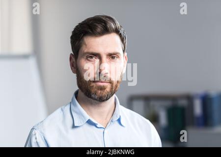 Portrait en gros plan d'un jeune homme d'affaires barbu, homme en chemise au bureau Banque D'Images