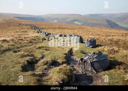 Sacs de roches et de gravier livrés par hélicoptère pour les travaux de réparation de sentiers, chef de la Fawyne dans les montagnes noires, par national de Brecon Beacons Banque D'Images