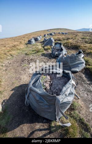 Sacs de roches et de gravier livrés par hélicoptère pour les travaux de réparation de sentiers, chef de la Fawyne dans les montagnes noires, par national de Brecon Beacons Banque D'Images