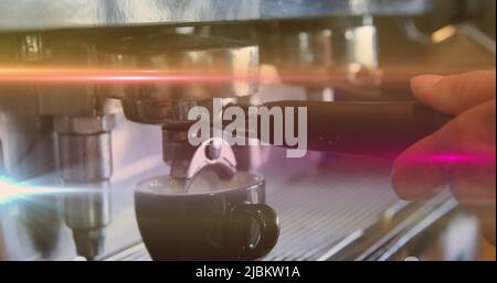 Image des taches de lumière sur l'homme biracial à l'aide d'une machine à café Banque D'Images