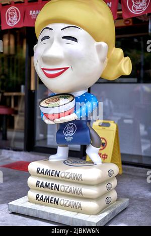 Extérieur du restaurant japonais avec grande statue distinctive d'une serveuse souriante Banque D'Images