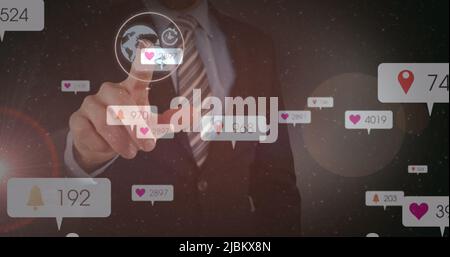 Image des icônes et des chiffres des réseaux sociaux sur un homme d'affaires touchant l'écran interactif Banque D'Images