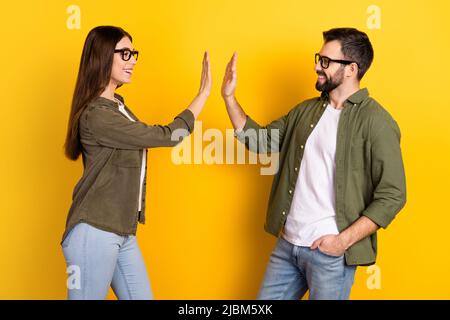 Profil photo de côté de deux partenaires joyeux donner haut cinq les uns les autres célèbrent la signature de contrat réussie isolé sur fond jaune couleur Banque D'Images