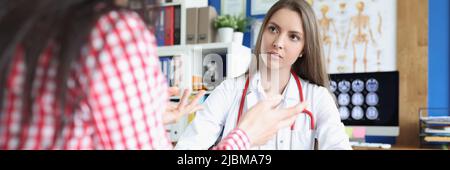 Portrait d'une femme médecin sérieuse écoutant attentivement le patient. Banque D'Images