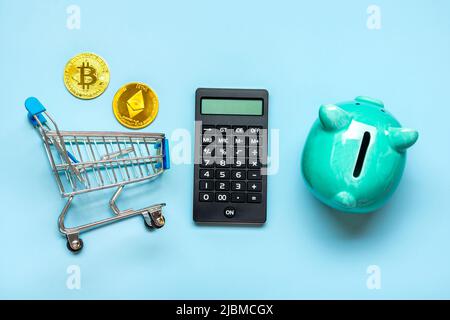 Banque de piggy, calculatrice et pièces de Bitcoin d'or, Ethereum isolé sur fond bleu accumulation de crypto-monnaie, investissement dans le marché de la crypto, Banque D'Images