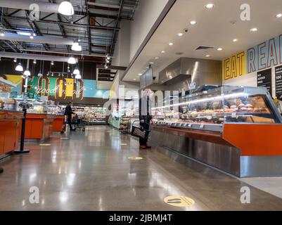 Kirkland, WA USA - vers septembre 2021 : vue d'un homme âgé portant un masque facial dans la zone de restauration de buffet chaud à l'intérieur d'un marché Whole Foods. Banque D'Images