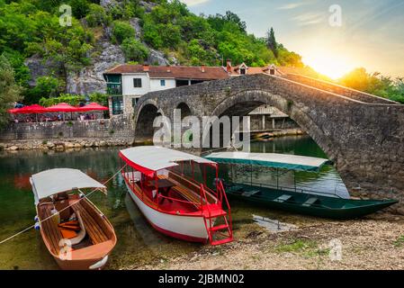 Coucher de soleil sur Stari Most et bateaux sur la rivière Crnojevica au Monténégro Banque D'Images