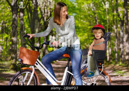 Mère avec un petit garçon blond sur e-bike à l'arrière Banque D'Images