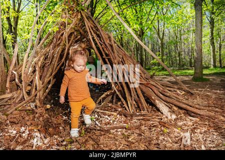 Belle fille jouer dans la cabane de forêt de branches ou de lickiup Banque D'Images