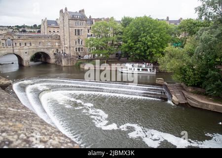 Pont de Pulteney Weir, Bath, Somerset, Angleterre, 26 mai 2022, un bateau de plaisance au bord du weir Banque D'Images