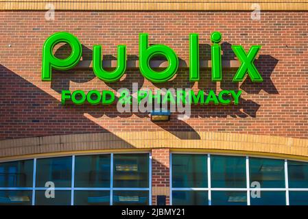 La façade extérieure de Publix Food and Pharmacy affiche la marque et le logo en vert néon avec des ombres au coucher du soleil à Charlotte, Caroline du Nord. Banque D'Images