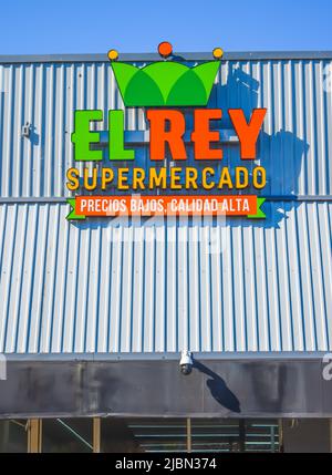 Façade extérieure du supermarché El Rey marque et logo en vert et orange sur un toit en métal blanc et nervuré avec un ciel lumineux bleu clair. Banque D'Images