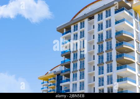 Façade moderne et aérée jaune et bleue avec fenêtres. Fragment d'un nouveau bâtiment résidentiel ou d'un complexe commercial. Partie de l'immobilier de ville. Banque D'Images