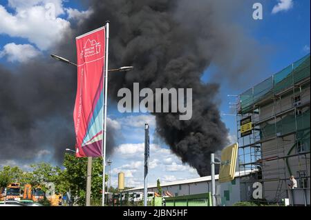 07 juin 2022, Saxe-Anhalt, Halle (Saale) : visible de loin, un nuage de fumée noire s'élève dans le ciel. Un roulement de roue a pris feu au centre de recyclage de la Hallesche Stadtwirtschaft. Plusieurs pompiers étaient sur place. Photo: Heiko Rebsch/dpa Banque D'Images