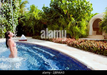 Une femme quitte le bain de vapeur lors d'un traitement traditionnel mexicain Temezcal au Spa Aqua de Live Aqua Resort & Spa. Banque D'Images